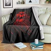 Black skull graphic blanket with red screaming skull design, folded over a bed