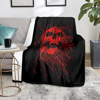 Black skull graphic blanket with red screaming skull design, draped on a sofa seat