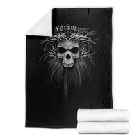 Black skull graphic blanket folded on a white background, with rolled towels
