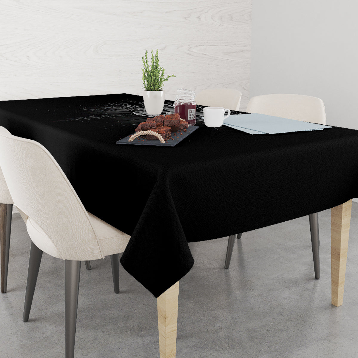 Black skull-themed tablecloth on dining table with items centered on top.