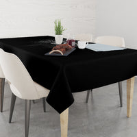 Black skull-themed tablecloth on dining table with items centered on top.