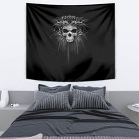 Black skull tapestry hanging above striped pillows and bedding
