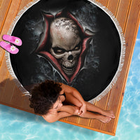 Round black beach blanket featuring skull face with red hood, spider web pattern, fringed