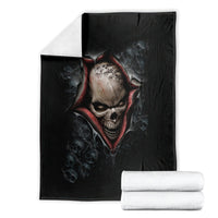 Black skeleton skull graphic blanket with red flame-like border, folded and stacked