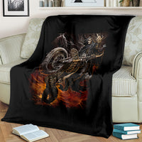 Black death-angel motorcycle blanket with flaming skull graphic, draped on cream couch