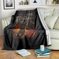 Black death-angel motorcycle blanket with flaming skull art, draped on striped couch