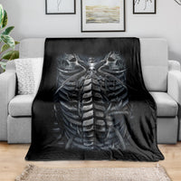 Black skeleton skull and spine blanket, spread over a couch seat