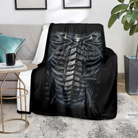 Black skeleton skull and spine blanket, draped over sofa back