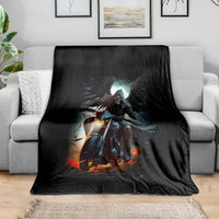 Black fantasy blanket with skull rider artwork, spread on a gray sofa