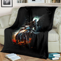 Black fantasy blanket with glowing skull rider print, draped over a cream sofa