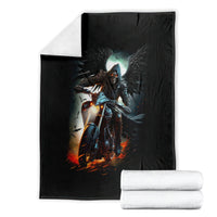 Black fantasy blanket with skull rider artwork, folded beside rolled white towels