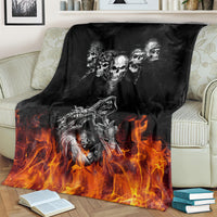 Black skull and motorcycle blanket, draped over a sofa with burning flames