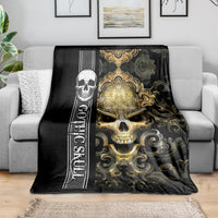 Black gothic skull blanket draped over sofa with gold skull and scrollwork design