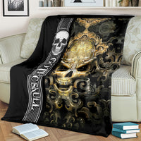 Black gothic skull blanket folded on couch with gold crowned skull and swirling motifs