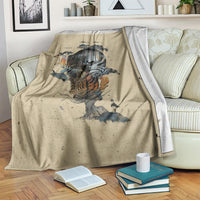 Beige skull graphic blanket draped on bed, books and mug on floor