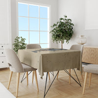 Beige tablecloth on dining table with centered skull graphic, draping over edges