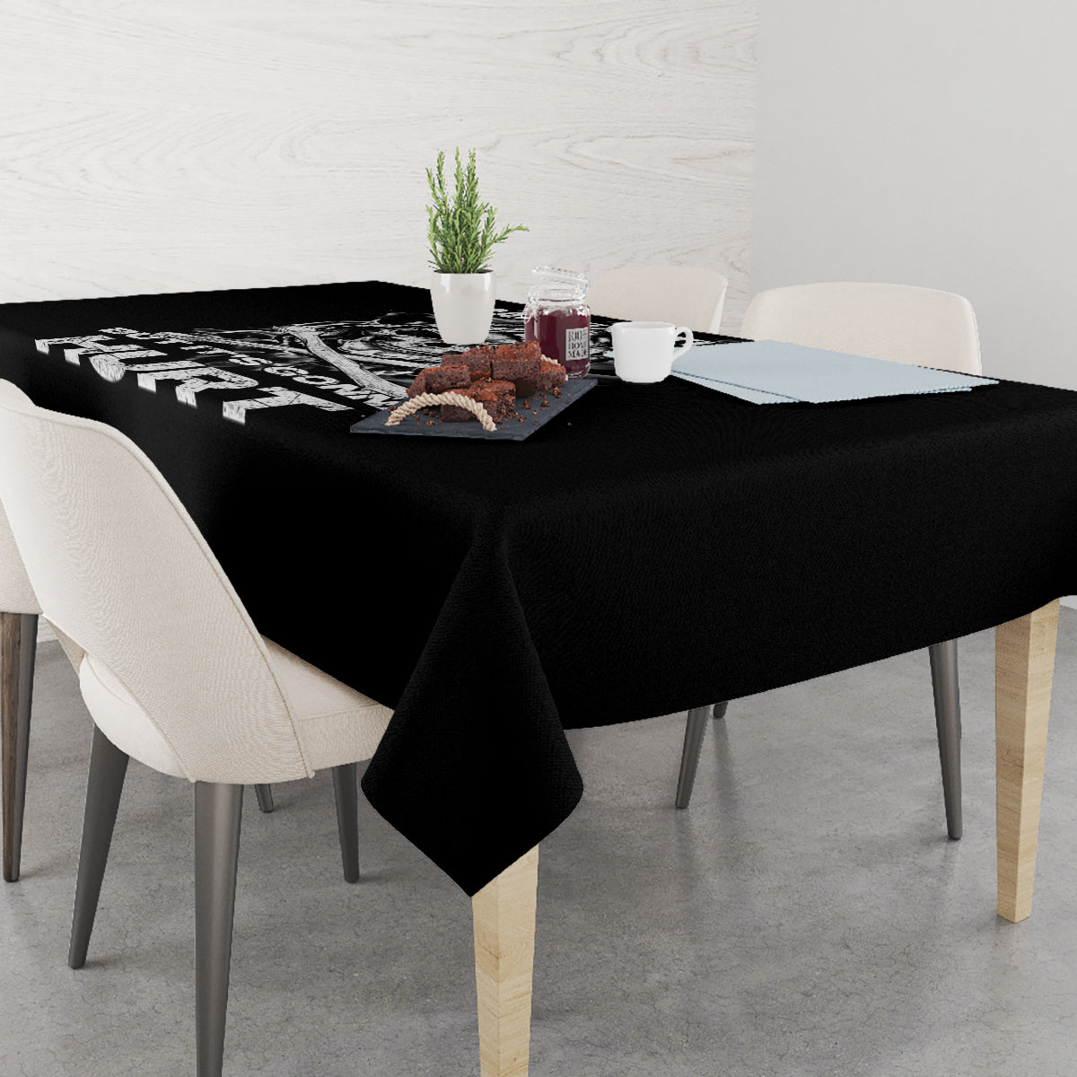 Black skull graphic tablecloth on dining table with chairs, corners neatly draped