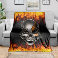 Black skull and chain blanket with fiery flames, draped over gray sofa