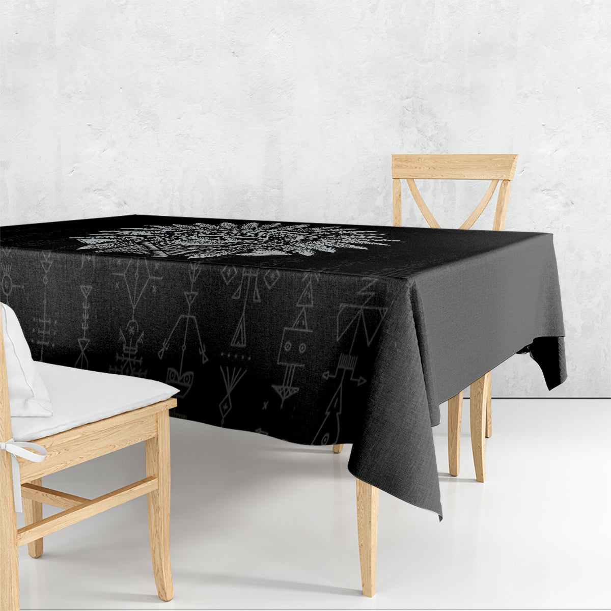 Black tablecloth draped on rectangular table, all-over tribal icon print
