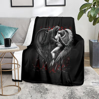 Black winged angel graphic blanket with red accents, shown on a living room seat