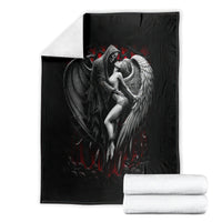 Black angel and wing graphic blanket with red accents, with rolled white towels