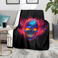 Black skull flame throw blanket on sofa, bright blue skull with fiery red-orange flames