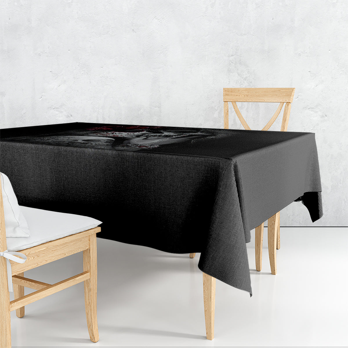 Black skull tablecloth with roses and skeleton figures, draped on a table