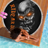 Black skull beach blanket with orange vertical text, round edge with white fringe