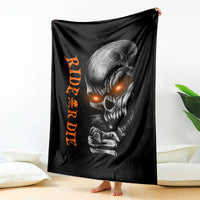 Black skull graphic blanket with orange lettering, draped over chair