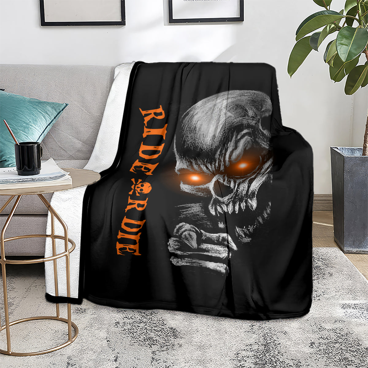 Black skull graphic blanket with orange lettering, laid on light rug