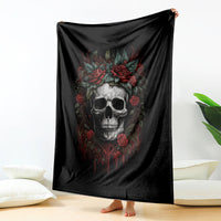 Black skull blanket with red roses held up, skull face graphic in center