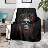 Black skull blanket with red roses over a gray sofa, centered skull graphic