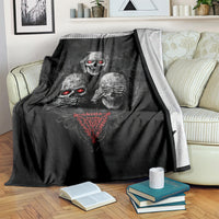 Black skull graphic throw blanket with red glowing eyes, draped on sofa