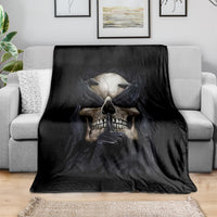 Black skull graphic blanket spread over a light sofa, skull artwork in the center