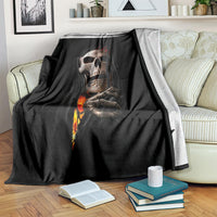 Black skull throw blanket with skeletal hands and flame graphic, draped over couch