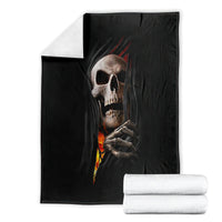 Black skull throw blanket with skeletal hands and flame design, folded display