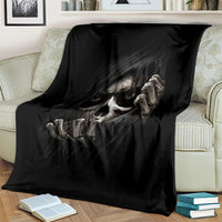 Black skull and skeleton graphic blanket, draped over a cream sofa