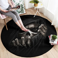 Black round area rug showing a skull and claw-like skeleton hands design