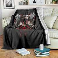 Black skull wing graphic blanket with red details, folded over striped throw