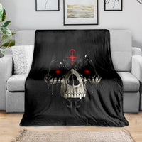 Black skull blanket with red eyes on living room sofa, draped over arm