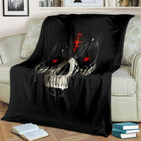 Black skull blanket with red eyes and dripping skull design, covering couch