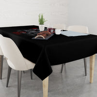 Black tablecloth on dining table with skull-and-crest design near the runner edge
