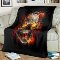 Black skull graphic blanket, draped over couch, fiery flames and clenched teeth