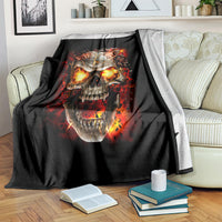 Black skull graphic blanket over sofa, fiery flames around a screaming skull