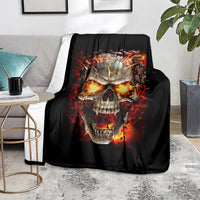 Black skull graphic blanket with burning flames, spread on light gray couch