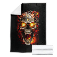 Black skull graphic throw blanket with fiery flames, folded with white towels