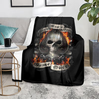 Black skull graphic blanket with flaming skull, spread on grey couch seat