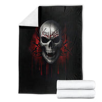 Black skull graphic blanket with red drips, shown folded with towels