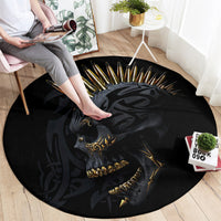Black round rug showing golden skull with spiked hair, chair-side view