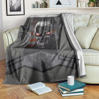 Black skull themed blanket with metal head graphic, draped over couch with books nearby